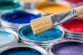 Colorful paint cans and a close up of a paintbrush Royalty Free Stock Photo