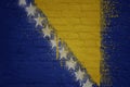 colorful painted big national flag of bosnia and herzegovina on a massive brick wall Royalty Free Stock Photo