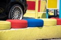 Colorful painted car tires standing in a row in front of a car wheel. Royalty Free Stock Photo
