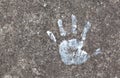Colorful painted childs hand print on the concrete floor symbol. Small, little child`s handprint reflected on the ground