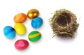 Colorful painted Easter eggs and empty bird`s nest on  white surface Royalty Free Stock Photo