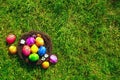 Colorful painted Easter eggs in nest on fresh green grass top view, Happy Easter Holliday concept background with copy