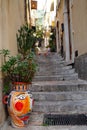 colorful painted vases and flower pots on narrow stairs in the old town of Taormina, Sicily