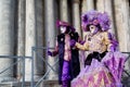 Colorful pair carnival purple-beige mask and costume at the traditional festival in Venice, Italy