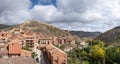 Colorful panoramic view of the medieval small village of Albarracin and its defensive wall in Autumn blue sky and white Royalty Free Stock Photo