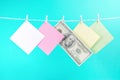 Colorful paper cards and money hanging rope isolated on blue background. Royalty Free Stock Photo