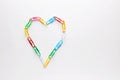 Colorful paper clips arranged as heart shape on white background Royalty Free Stock Photo