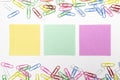 Colorful paper clips and 3 nore papers in the centre isolated on white Royalty Free Stock Photo