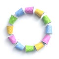 Colorful paper cups with polka dot pattern arranged in circle frame