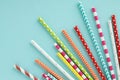 Colorful paper drinking straws on blue background. Royalty Free Stock Photo