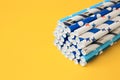 Colorful paper drinking straws on yellow background, closeup. Space for text Royalty Free Stock Photo