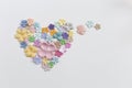 Colorful paper flower arrange in heart shape on white paper texture background Royalty Free Stock Photo