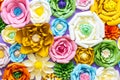 Colorful paper flowers on wall. Handmade artificial floral decoration. Spring abstract beautiful background and texture Royalty Free Stock Photo