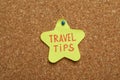 Colorful paper note with phrase Travel Tips pinned to cork board, closeup Royalty Free Stock Photo