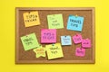 Colorful paper notes pinned to cork board on yellow wall. Travel tips and tricks Royalty Free Stock Photo