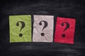 Colorful paper notes with question marks on black board Royalty Free Stock Photo