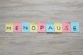 Colorful paper notes with word Menopause on wooden table, flat lay