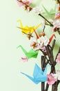 Colorful paper origami birds on flowering branches of cherry Royalty Free Stock Photo