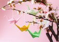 Colorful paper origami birds on flowering branches of cherry Royalty Free Stock Photo