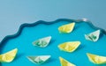 Colorful paper ships in blue water. Conceptual setting. Pastel background Royalty Free Stock Photo