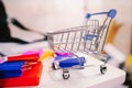 Colorful paper shopping bag in trolley on laptop