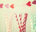 Colorful paper straws with a garland of hearts Royalty Free Stock Photo