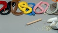 Colorful Paper Strips on a gray background with quilling needle and googly eyes