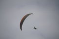 Colorful paraplane flying in the grey shaded sky