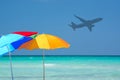 Colorful parasols and airplane turquoise water