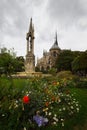 Colorful park with flowers and Notre Dame in a distance in Paris, France, vertical shot Royalty Free Stock Photo