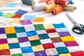 Colorful part of quilt sewn from square pieces, spools of thread, scissors, quilting and sewing accessories Royalty Free Stock Photo