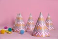 Colorful party hats, blower and fluffy balls on pink background Royalty Free Stock Photo