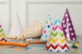 Colorful party hats and festive items on grey table near white wall indoors Royalty Free Stock Photo