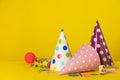 Colorful party hats and festive items on yellow background. Space for text Royalty Free Stock Photo
