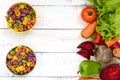 Colorful pasta in a bowls on a white wooden background, with fresh vegetables beets, greens, carrots, tomatoes, peppers. Royalty Free Stock Photo