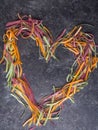 colorful pasta fettuccine, tagliatelle, uncooked pasta spaghetti macaroni in heart shape Royalty Free Stock Photo