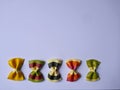 Colorful Pasta, Loop Noodles, Italian Pasta, five Farfalle. Closeup, in a row, side by side, in front of white background 