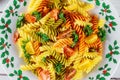 Colorful pasta rotini, cherry tomatoes on christmas plate. Close up Royalty Free Stock Photo