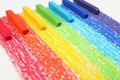 Colorful pastel chalks on rainbow painting, closeup. Drawing materials