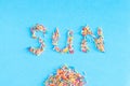 Colorful pastry sprinkes background. Sun - word inscription