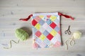 Colorful patchwork drawstring bag, green and yellow yarn, scissors Royalty Free Stock Photo