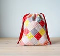 Colorful patchwork drawstring bag on wooden table