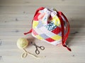 Colorful patchwork drawstring bag, yellow yarn and scissors Royalty Free Stock Photo