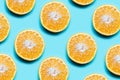 Colorful pattern of cutted orange fruits on background of cyan color. Royalty Free Stock Photo