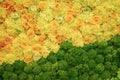 Colorful pattern of yellow roses and bright foliage, flower texture background, top view, floral wallpaper for design Royalty Free Stock Photo