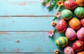 Colorful patterned Easter eggs and flowers rest on a rustic blue wood table. Spring celebration tradition, festive decoration, Royalty Free Stock Photo