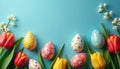 Colorful patterned Easter eggs, vibrant tulips arranged on bright blue background. White delicate blossoms, green leaves complete Royalty Free Stock Photo