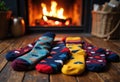 Colorful patterned socks arranged in front of a cozy fireplace Royalty Free Stock Photo