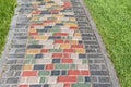 Colorful paved road across lush lawn on sunny day