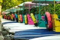 Colorful pedal boats anchor at pier in park.